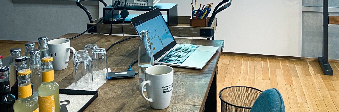 Foto von einem Laptop mit Kaffeetasse im enpit Büro Paderborn